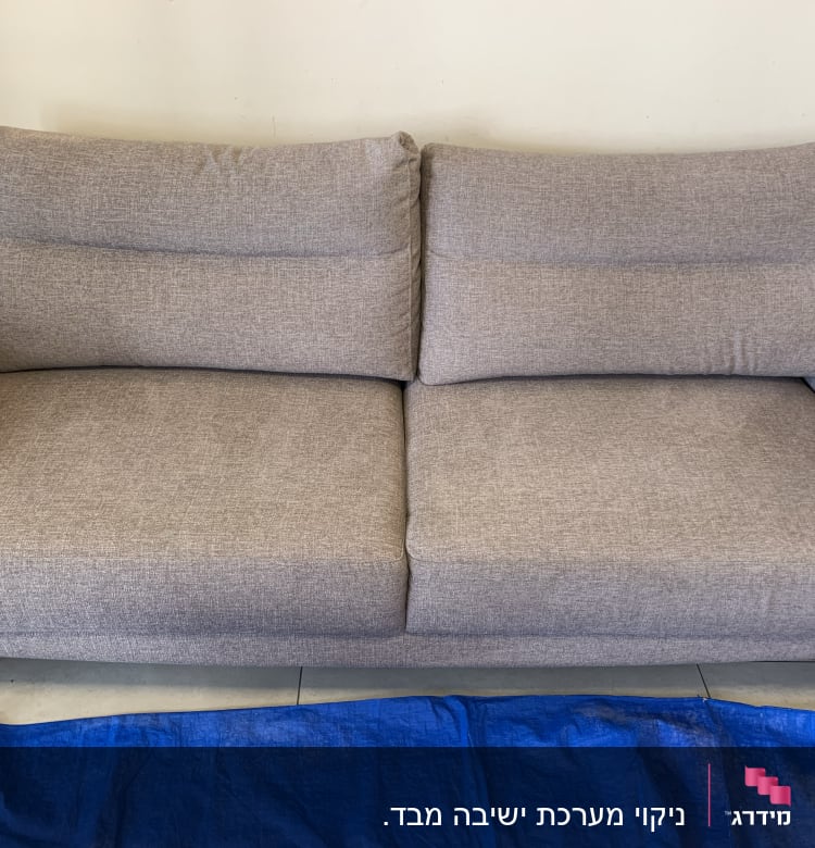 ספה אפורה עם כיסוי כחול לניקוי